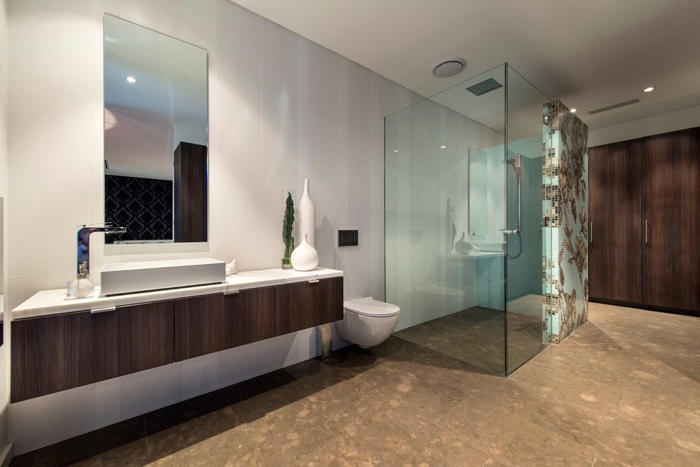 Photo of a mid-sized contemporary kids bathroom in Perth with a vessel sink, flat-panel cabinets, dark wood cabinets, marble benchtops, an open shower, a wall-mount toilet, black tile, stone tile, white walls and limestone floors.