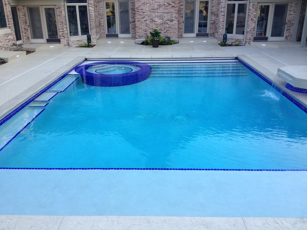 Inspiration for a large transitional backyard concrete paver and rectangular natural hot tub remodel in Cedar Rapids