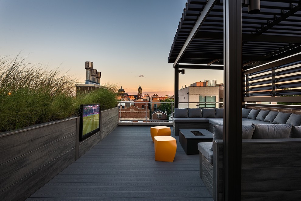 Photo of an expansive modern rooftop deck in Chicago with with fireplace and a pergola.