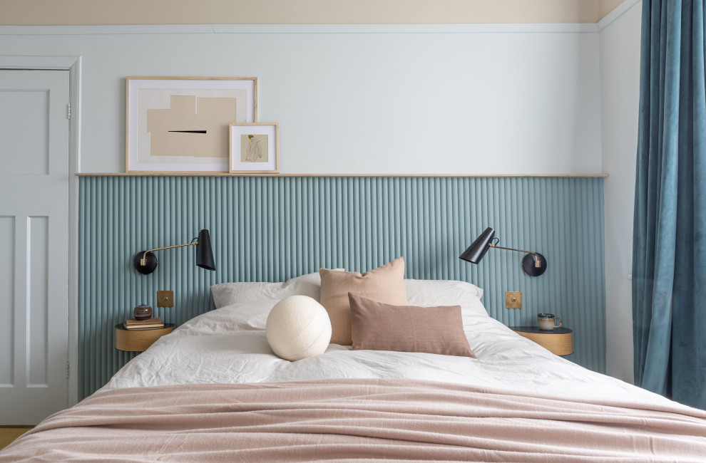 Inspiration för små moderna huvudsovrum, med blå väggar, heltäckningsmatta, en standard öppen spis, en spiselkrans i trä och gult golv