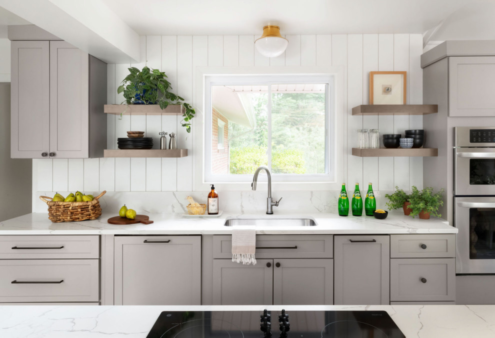 Diseño de cocina clásica renovada con fregadero bajoencimera, armarios estilo shaker, puertas de armario grises y encimeras blancas