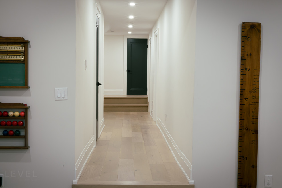 Kleiner Moderner Flur mit weißer Wandfarbe, hellem Holzboden und braunem Boden in Toronto