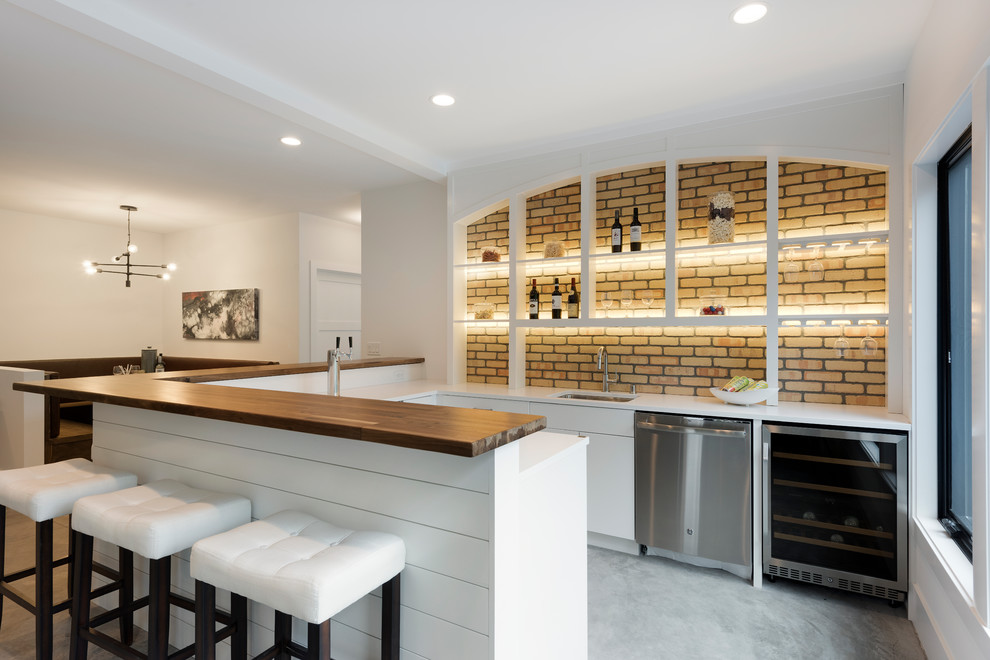 This is an example of a mid-sized modern u-shaped seated home bar in Minneapolis with an undermount sink, flat-panel cabinets, white cabinets, concrete floors and grey floor.