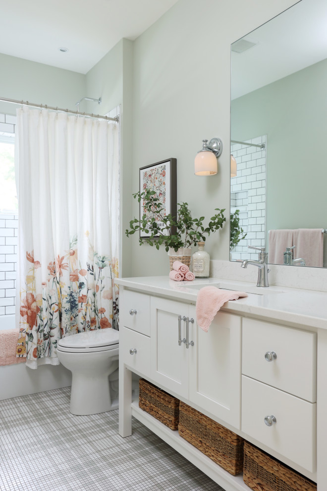 Exemple d'une salle de bain bord de mer avec un placard à porte shaker, des portes de placard blanches, une baignoire en alcôve, un combiné douche/baignoire, un mur vert, un sol en carrelage de terre cuite, un lavabo encastré, un sol multicolore, une cabine de douche avec un rideau, un plan de toilette blanc, meuble simple vasque et meuble-lavabo sur pied.