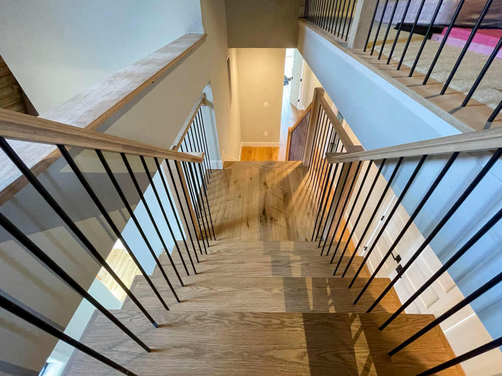 This is an example of an expansive traditional wood straight mixed railing staircase in DC Metro with wood risers.
