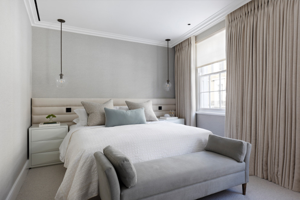 Transitional bedroom in London with grey walls, carpet and grey floor.