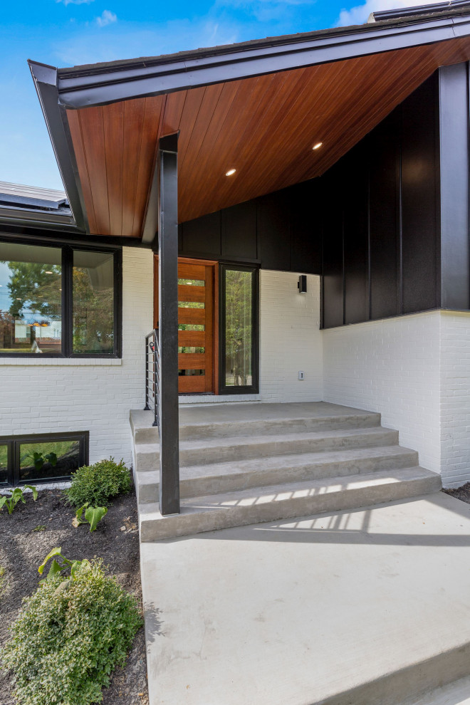 Ejemplo de fachada negra y negra minimalista de tamaño medio con tejado a dos aguas