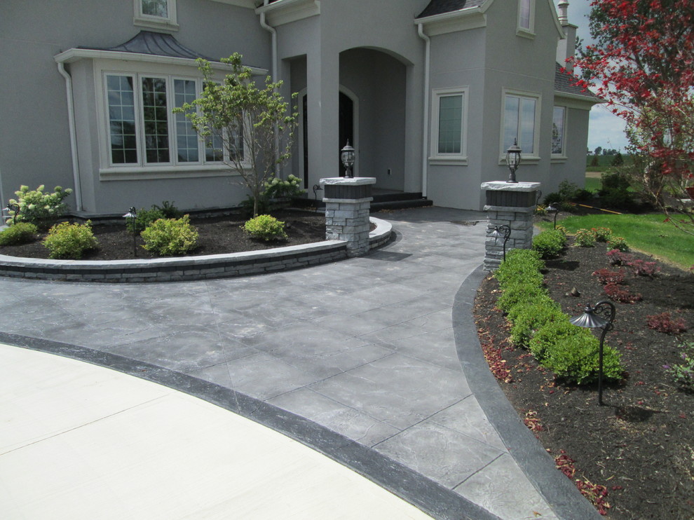 This is an example of an expansive modern front yard garden in Other with natural stone pavers.