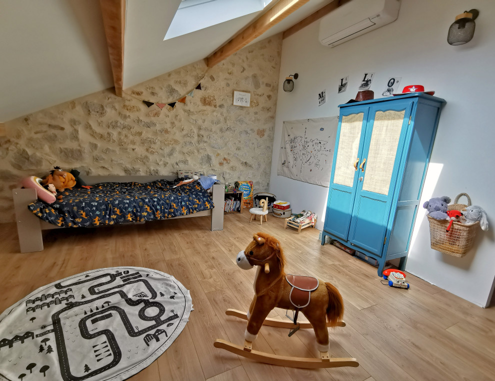 Ispirazione per una grande cameretta per bambini da 4 a 10 anni minimalista con pareti bianche, pavimento in laminato, pavimento beige e travi a vista