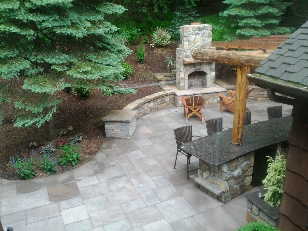 Photo of a mid-sized traditional backyard patio in New York with a fire feature, natural stone pavers and a pergola.