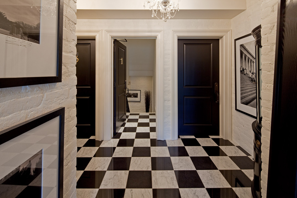 This is an example of a traditional entryway in Toronto with a black front door, marble floors and multi-coloured floor.