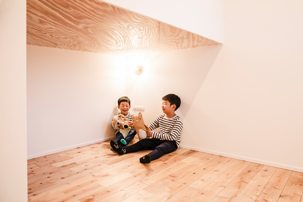 Modernes Jungszimmer mit weißer Wandfarbe und hellem Holzboden in Sonstige
