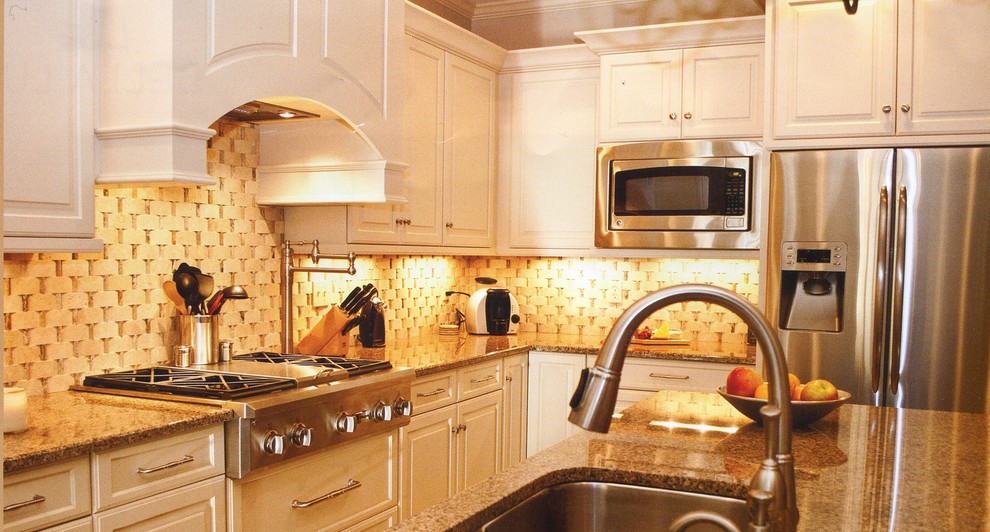 Enclosed kitchen - large l-shaped enclosed kitchen idea in DC Metro with an undermount sink, raised-panel cabinets, white cabinets, granite countertops, beige backsplash, stone tile backsplash, stainless steel appliances and an island