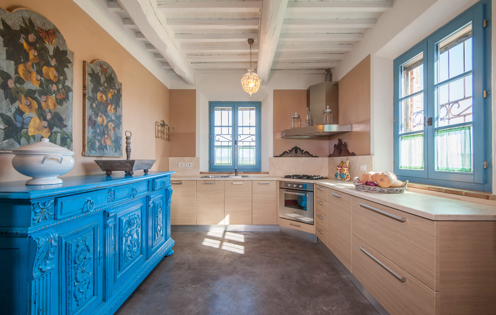 This is an example of a mid-sized mediterranean l-shaped kitchen in Florence with flat-panel cabinets, concrete floors, no island, grey floor, beige benchtop, a double-bowl sink, light wood cabinets, beige splashback and stainless steel appliances.