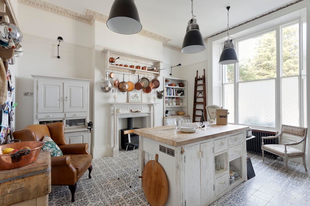 This is an example of a traditional kitchen in Sussex with open cabinets, wood benchtops and with island.