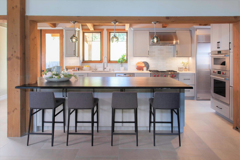 Open concept kitchen - large rustic galley porcelain tile, gray floor and wood ceiling open concept kitchen idea in Denver with an undermount sink, recessed-panel cabinets, gray cabinets, quartzite countertops, white backsplash, cement tile backsplash, stainless steel appliances, an island and white countertops