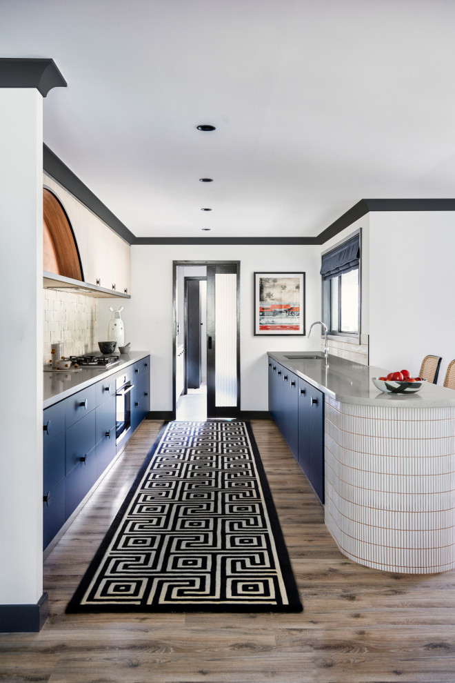 Exempel på ett stort modernt grå grått kök, med en undermonterad diskho, släta luckor, blå skåp, bänkskiva i kvarts, grönt stänkskydd, stänkskydd i terrakottakakel, svarta vitvaror, ljust trägolv, en köksö och grått golv