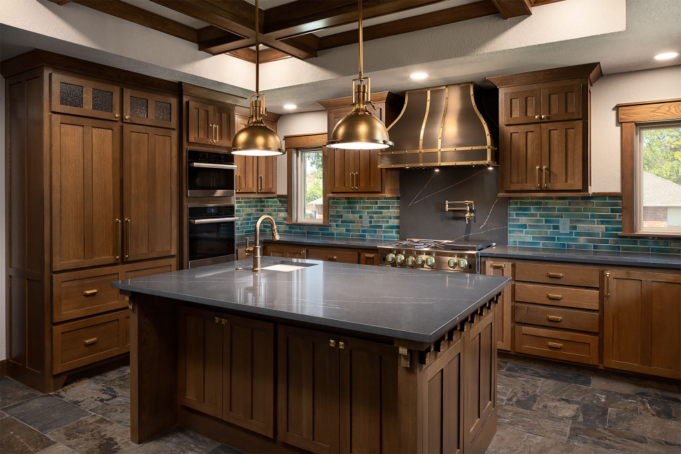Mid-sized arts and crafts slate floor and coffered ceiling kitchen photo in Oklahoma City with a farmhouse sink, shaker cabinets, medium tone wood cabinets, quartz countertops, blue backsplash, an island and gray countertops