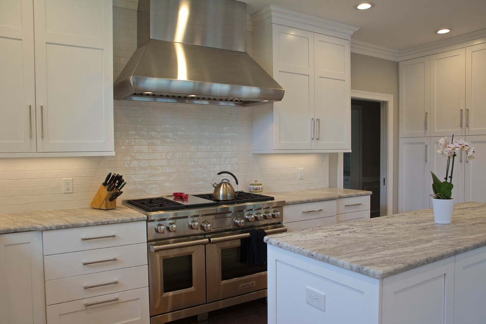 Eat-in kitchen - large transitional l-shaped medium tone wood floor and brown floor eat-in kitchen idea in Cincinnati with an undermount sink, shaker cabinets, white cabinets, granite countertops, white backsplash, ceramic backsplash, paneled appliances and an island