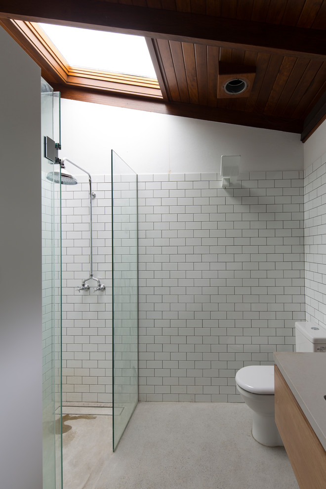 Design ideas for a small contemporary master bathroom in Sydney with flat-panel cabinets, grey cabinets, an alcove shower, a one-piece toilet, white tile, subway tile, white walls, solid surface benchtops, a hinged shower door and brown benchtops.