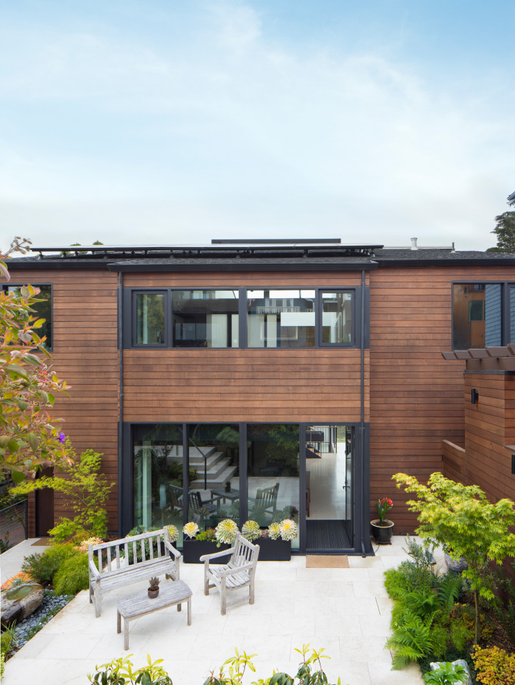 Стильный дизайн: деревянный, коричневый, трехэтажный частный загородный дом среднего размера в стиле модернизм с двускатной крышей, крышей из гибкой черепицы, черной крышей, входной группой и отделкой планкеном - последний тренд