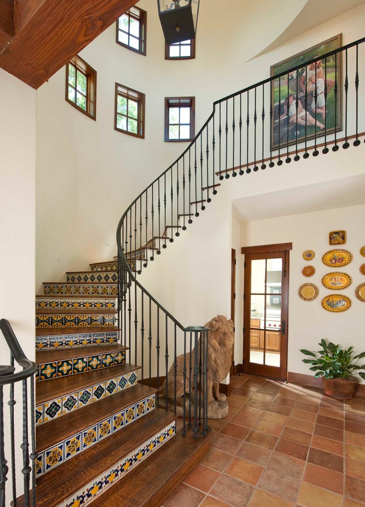 Inspiration for a mediterranean wood curved staircase in San Diego with tile risers and metal railing.