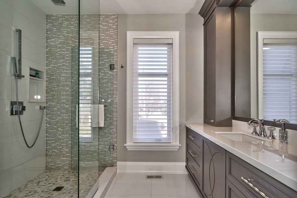 Photo of a mid-sized contemporary bathroom in Toronto with shaker cabinets, brown cabinets, a curbless shower, white tile, grey walls, marble floors, an undermount sink and engineered quartz benchtops.