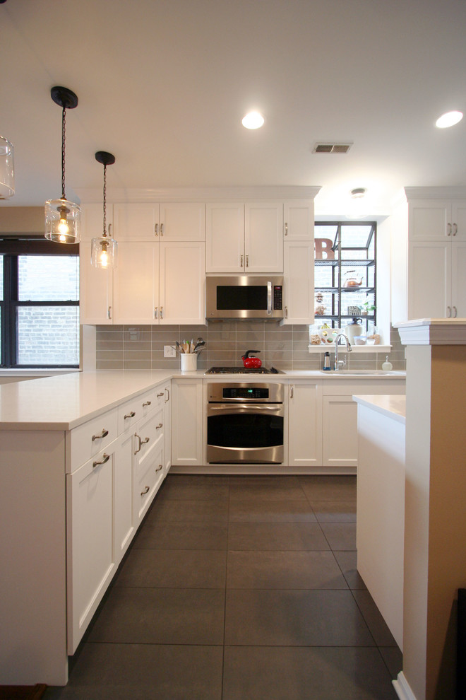 Mid-sized transitional u-shaped porcelain tile open concept kitchen photo in Chicago with an undermount sink, shaker cabinets, white cabinets, quartzite countertops, gray backsplash, subway tile backsplash, stainless steel appliances and a peninsula