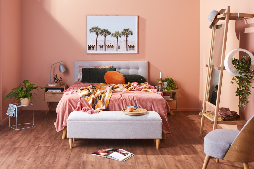 Ejemplo de dormitorio principal bohemio de tamaño medio sin chimenea con paredes rosas, suelo vinílico y suelo marrón