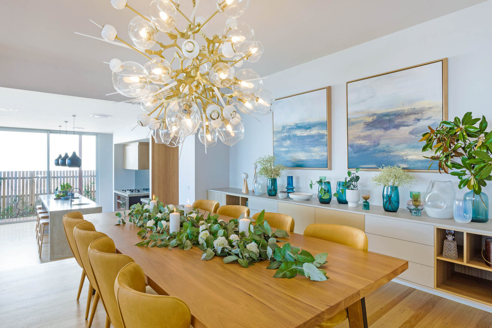 Design ideas for a large beach style dining room in Sydney with beige walls, light hardwood floors and wallpaper.