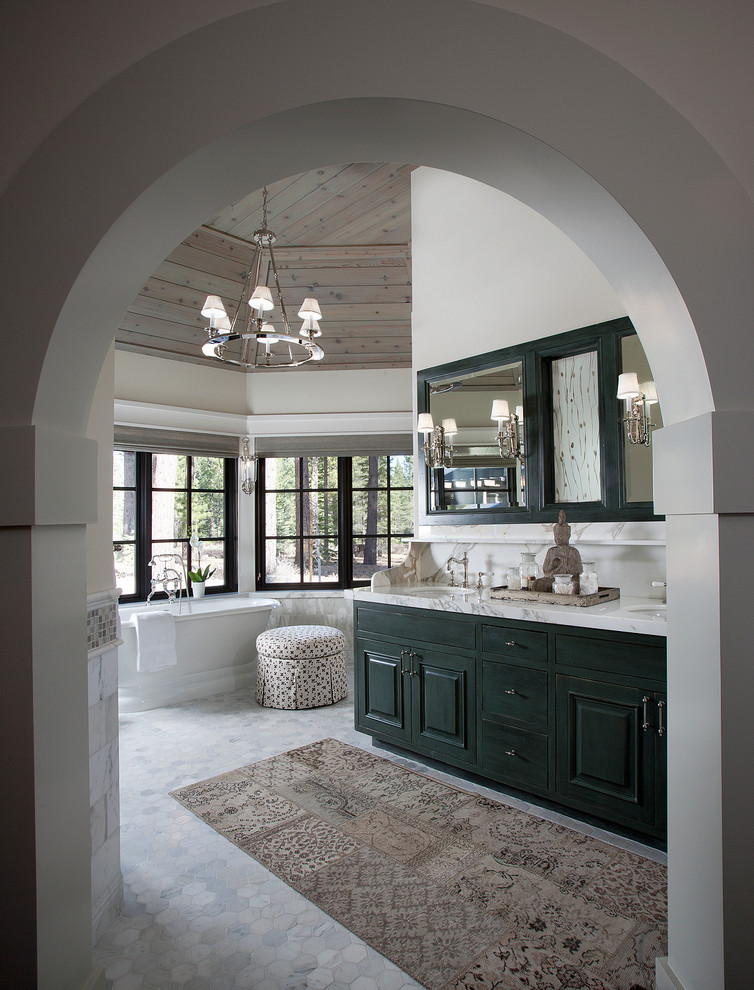 Country bathroom in Sacramento with raised-panel cabinets, a freestanding tub and white walls.