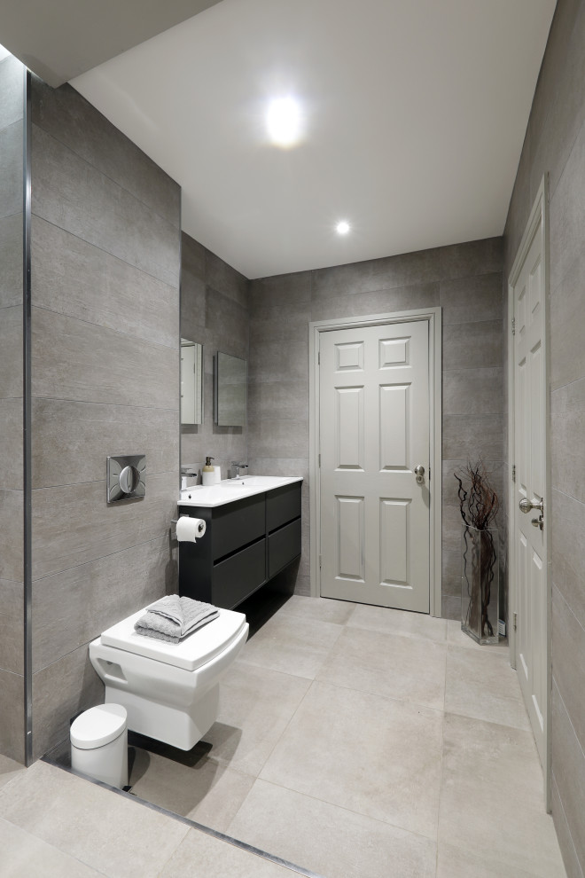 Design ideas for a large contemporary wet room bathroom in Sussex with flat-panel cabinets, black cabinets, a wall-mount toilet, gray tile, an integrated sink, grey floor, an open shower and white benchtops.