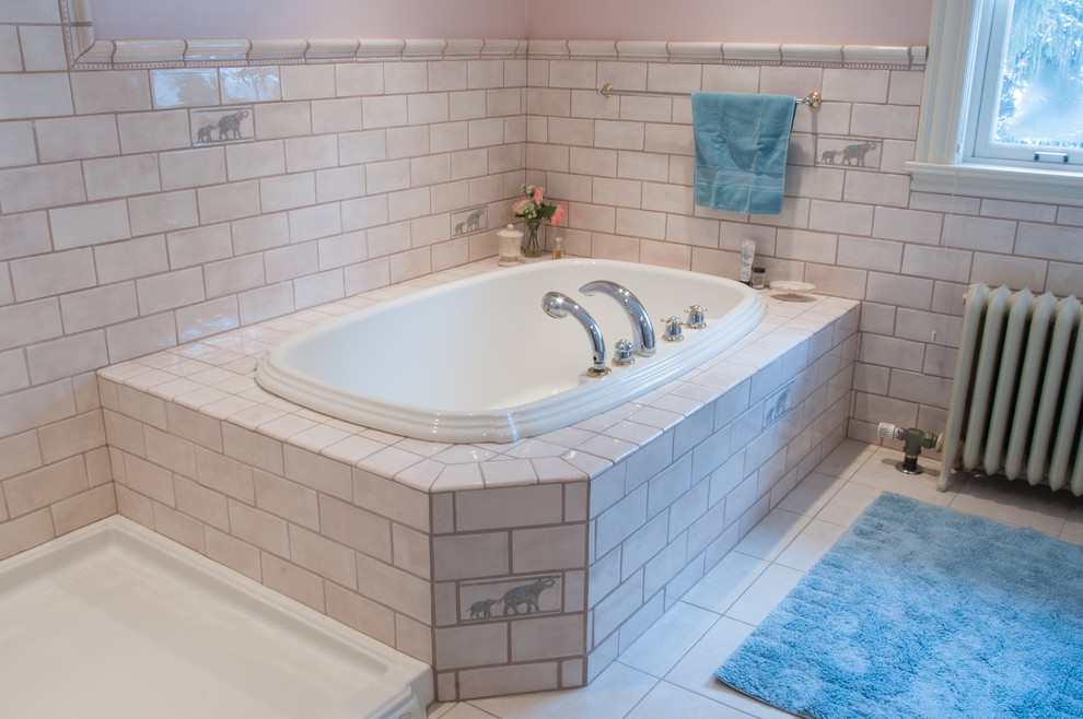 This is an example of a contemporary master bathroom in Other with white cabinets, a drop-in tub, a corner shower, ceramic floors, raised-panel cabinets, white tile, ceramic tile, pink walls, a drop-in sink and tile benchtops.