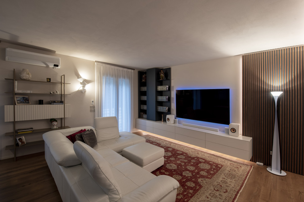Immagine di un soggiorno minimalista di medie dimensioni e aperto con libreria, pareti beige, parquet chiaro, TV a parete, pavimento marrone e soffitto ribassato