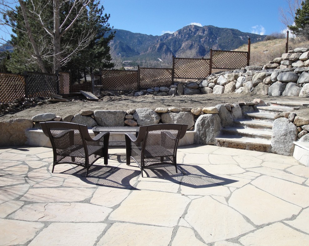 Example of a large transitional backyard stone patio design in Denver with no cover
