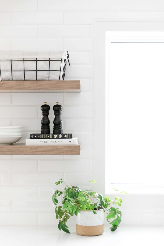 Large transitional u-shaped medium tone wood floor and brown floor eat-in kitchen photo in Calgary with an undermount sink, shaker cabinets, white cabinets, quartzite countertops, white backsplash, subway tile backsplash, stainless steel appliances, an island and white countertops