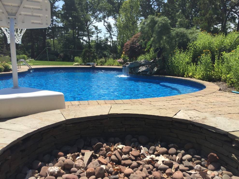 Photo of a traditional backyard pool in New York with a water feature.