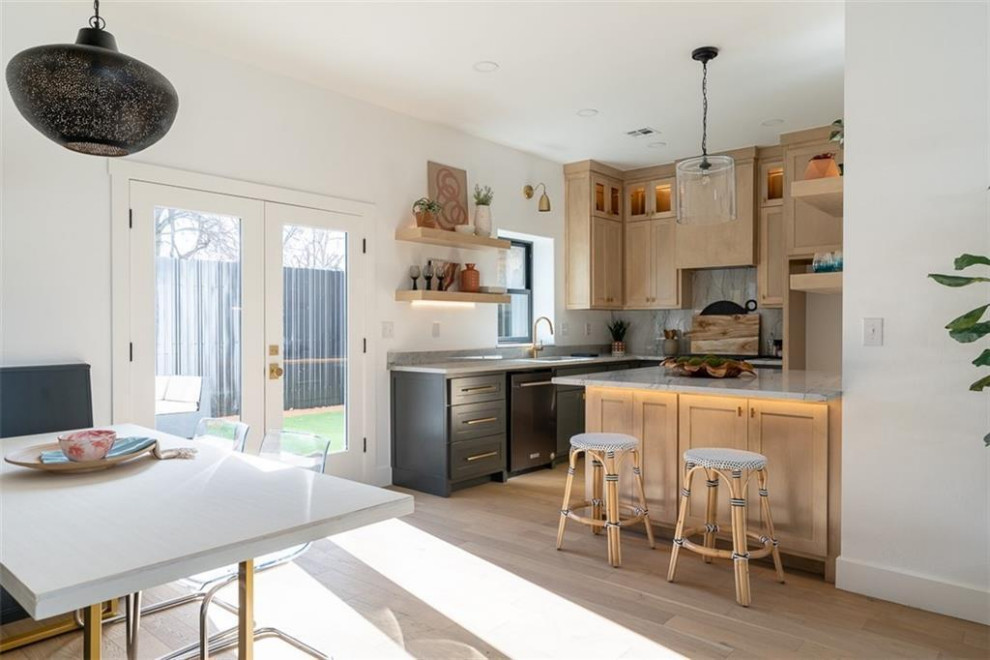 Mediterrane Wohnküche in L-Form mit Küchenrückwand in Grau, Rückwand aus Marmor, Kücheninsel und braunem Boden in Oklahoma City