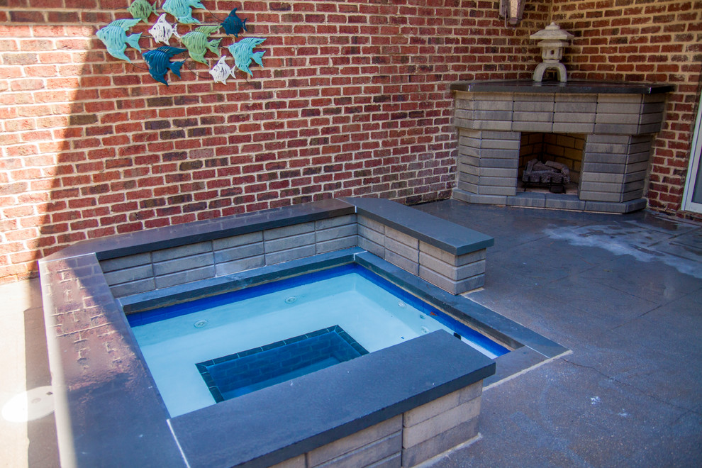 This is an example of a small contemporary backyard rectangular pool in Raleigh with a hot tub and concrete pavers.