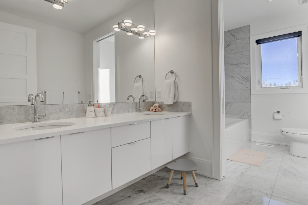 Photo of a mid-sized contemporary master bathroom in Calgary with flat-panel cabinets, white cabinets, a one-piece toilet, white tile, cement tile, white walls, an undermount sink, engineered quartz benchtops, white benchtops, a double vanity and a floating vanity.