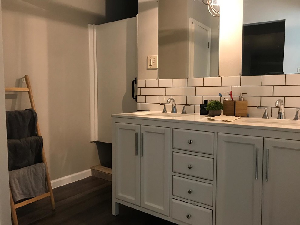 Bathroom - mid-sized transitional 3/4 dark wood floor and brown floor bathroom idea in Houston with recessed-panel cabinets, white cabinets, white walls, an undermount sink, quartz countertops and white countertops