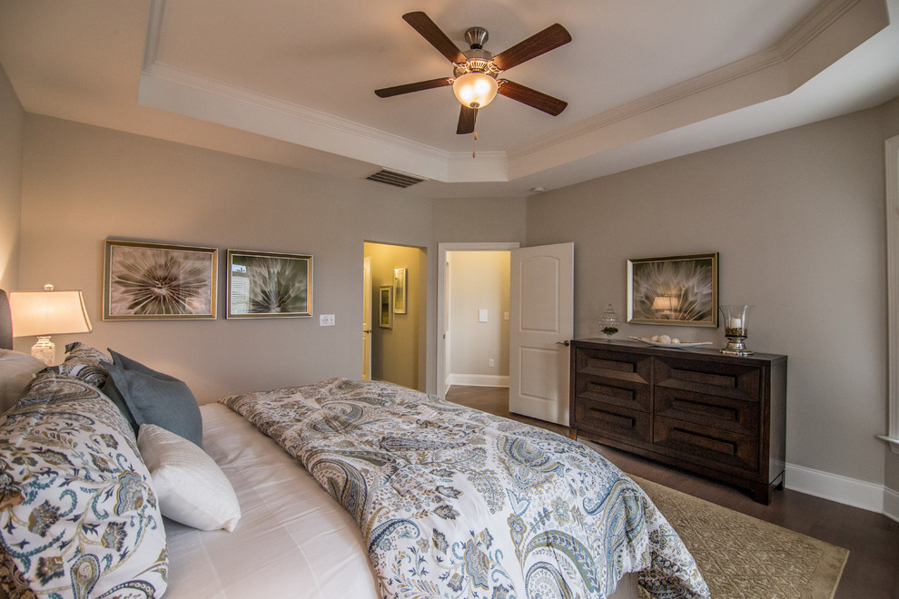 This is an example of a large transitional master bedroom in San Diego with grey walls and light hardwood floors.