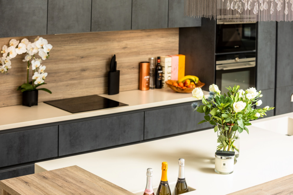 Design ideas for a large contemporary single-wall eat-in kitchen in Other with an integrated sink, flat-panel cabinets, grey cabinets, solid surface benchtops, timber splashback, panelled appliances, with island and beige benchtop.