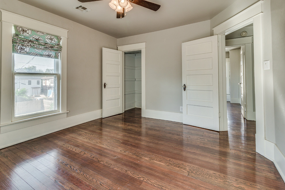 This is an example of a large modern master bedroom in Oklahoma City with grey walls, dark hardwood floors and orange floor.
