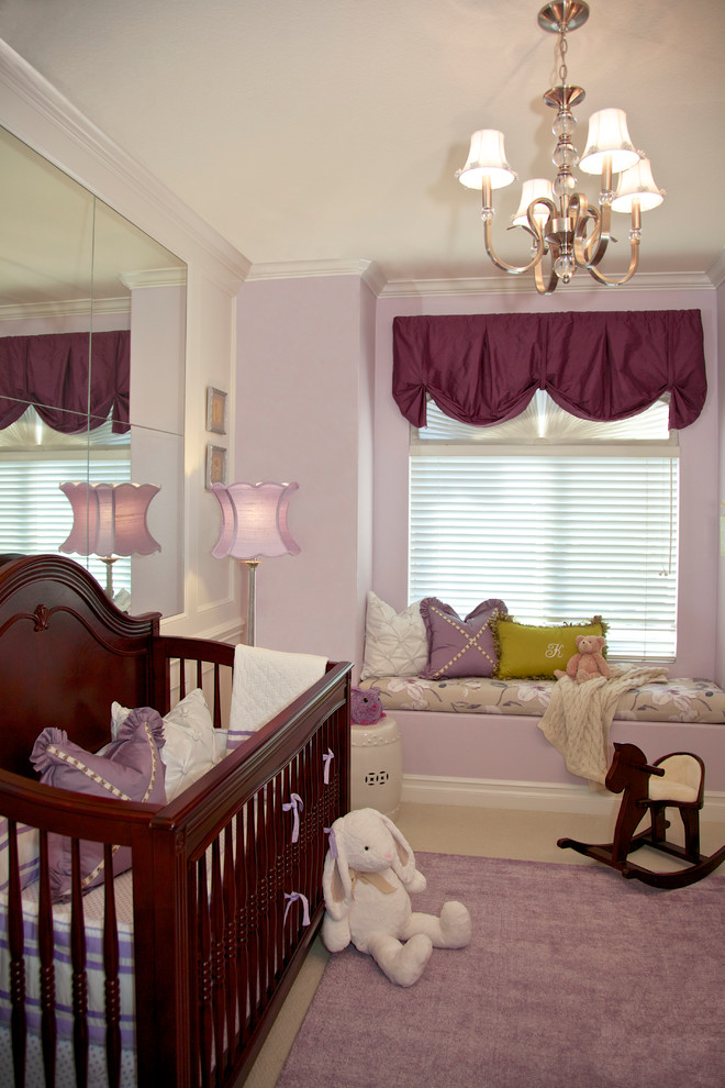 This is an example of a traditional nursery for girls in Orange County with purple walls and carpet.