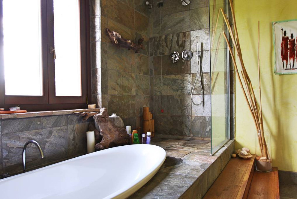 ミラノにある中くらいなカントリー風のおしゃれなマスターバスルーム (オープンシェルフ、ヴィンテージ仕上げキャビネット、ドロップイン型浴槽、バリアフリー、壁掛け式トイレ、石スラブタイル、スレートの床) の写真
