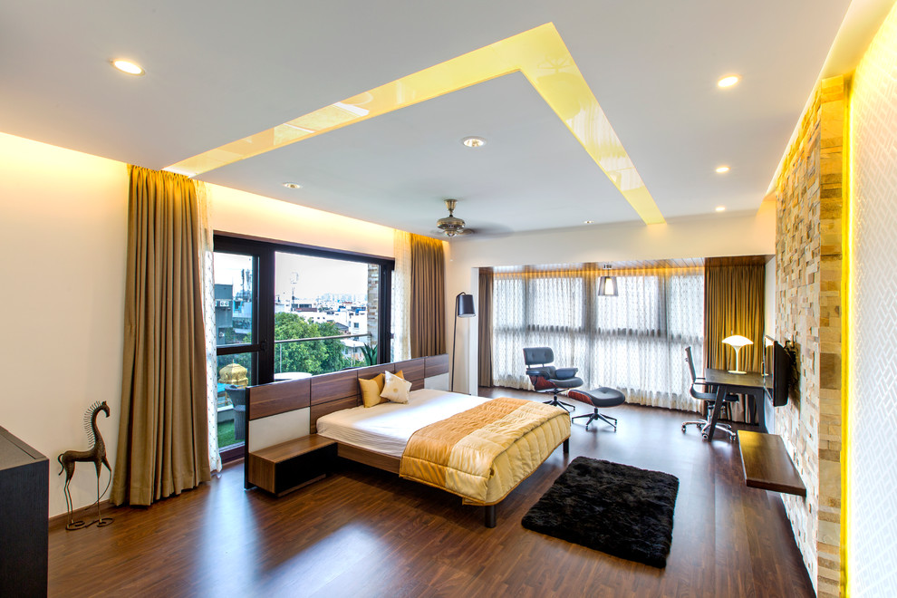This is an example of a large bedroom in Bengaluru with dark hardwood floors.