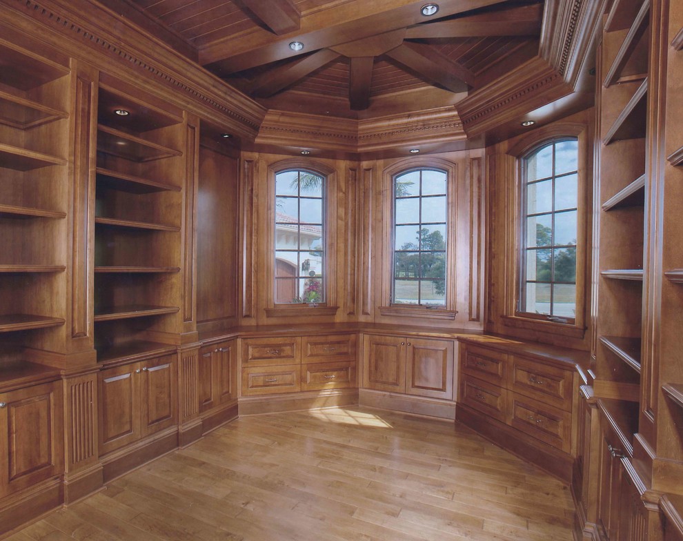 Cette image montre un grand bureau traditionnel avec un mur marron, un sol en bois brun, un bureau indépendant et un sol marron.