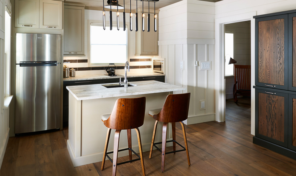 Idéer för ett litet lantligt vit kök, med en enkel diskho, luckor med infälld panel, bruna skåp, granitbänkskiva, vitt stänkskydd, stänkskydd i stenkakel, rostfria vitvaror, mellanmörkt trägolv, en köksö och brunt golv