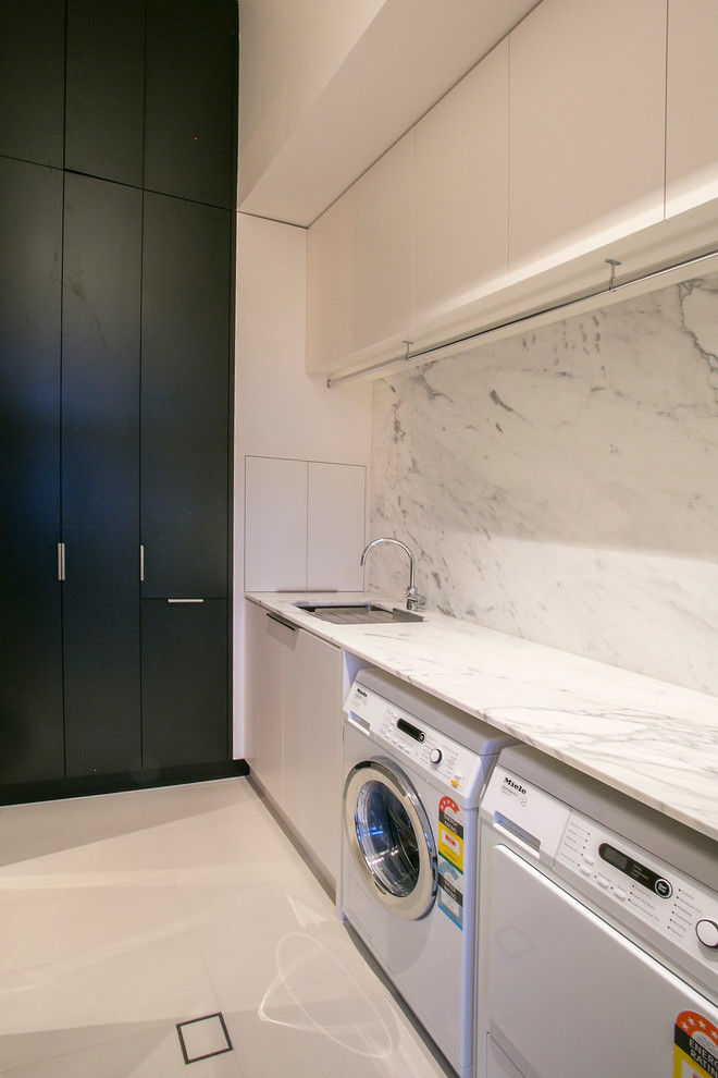 Large modern laundry room in Adelaide with an undermount sink, marble benchtops and a side-by-side washer and dryer.